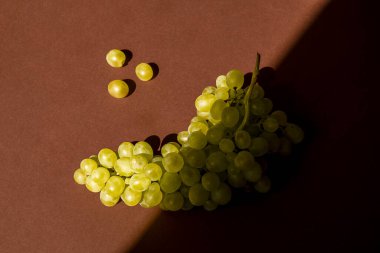 Kahverengi arka planda üzümler. Bir sürü. Doğal güneş ışığı.