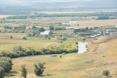 Güneşli bir yaz gününde ovalardan güzel bir nehir akar. Peyzaj.
