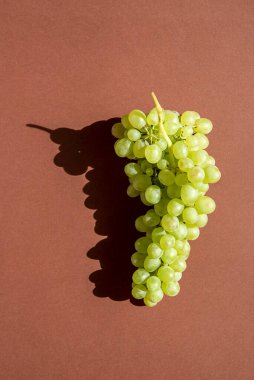 Kahverengi arka planda üzümler. Bir sürü. Doğal güneş ışığı.