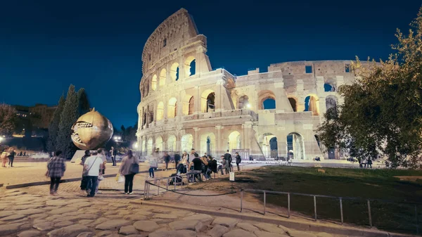 Römisches kolosseum und touristen in der nacht in rom, italien, menschen verschwommen — Stockfoto