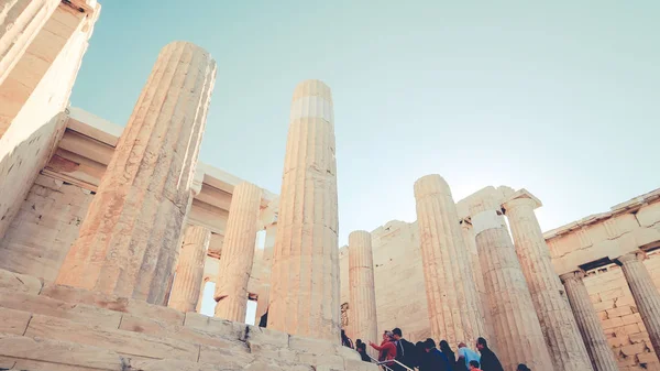 Turyści odwiedzić starożytne ruiny Propylaia na Akropol w Atenach, Grecja — Zdjęcie stockowe
