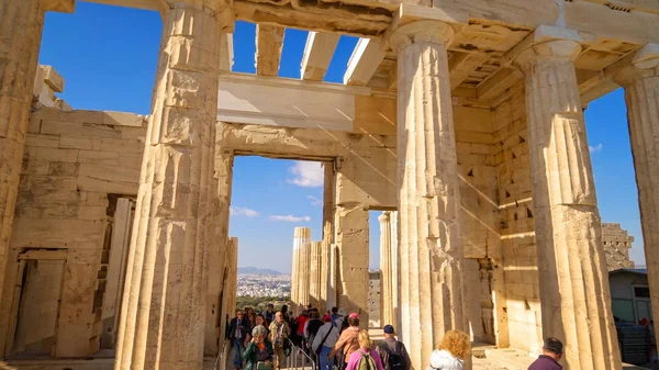 Touristen spazieren durch antike Ruinen in Akropolis, Athen, Griechenland lizenzfreie Stockbilder