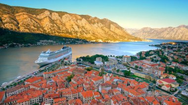 Skyline of Old Town, Kotor, Montenegro with Cruise Ship in Bay of Kotor, ship logos removed for commercial use clipart