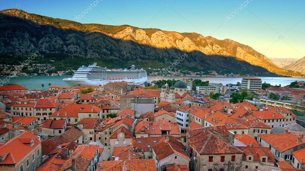 Skyline of Old Town, Kotor, Montenegro and cruise ship at sunrise, ships logos removed for commercial use