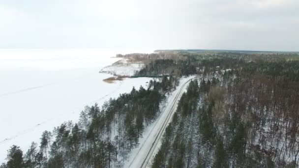 Aérea Paisaje Invernal Con Mar Congelado Carretera Madera — Vídeos de Stock