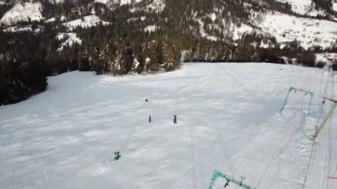 Hava. Kayakçı siluetleri üzerinde teleferik.
