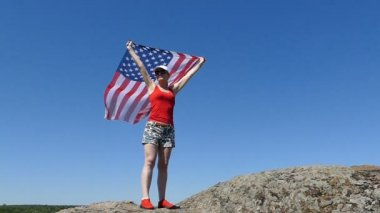 Seksi kadın kırmızı fanila açık witn Amerikan bayrağı stand. Ağır çekim