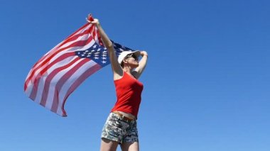 Kırmızılı uyumlu kadın witn Amerikan bayrağı stand. Ağır çekim,