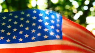 Ağır çekimde Amerikan bayrağı olay yerini kapatın. Orman yeşil arka plan