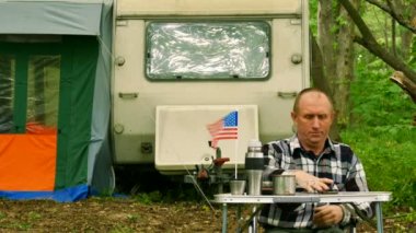 4k. Adam seyahat römork ile ahşap ve gülümseme Amerikan bayrağı ile kendi kendine çekim yapmak