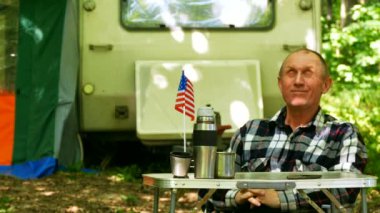 4k. Adam seyahat römork ile ahşap Amerikan bayrağı ile masaya oturmak 