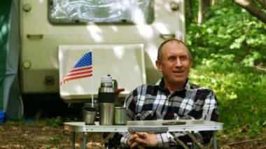 4k. Adam seyahat römork ile atış ahşap yaklaşım Amerikan bayrağı ile masaya oturmak