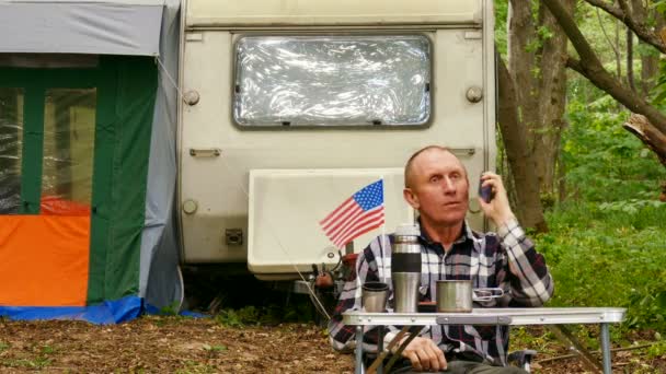 美国男子旅行者谈话手机在木头 — 图库视频影像