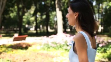       Güzel genç kız baş ve gülümsüyor güneş yaz parkta döner. Ağır çekim