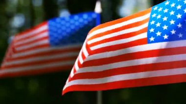   Ağır çekimde iki Amerikan bayrakları kadar güneşli ahşap kapatın. Rüzgarlı bir gün 