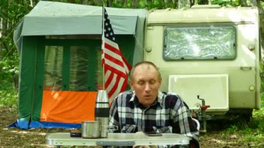 4k. Adam seyahat römork ile ahşap ve gülümseme Amerikan bayrağı ile kendi kendine çekim yapmak