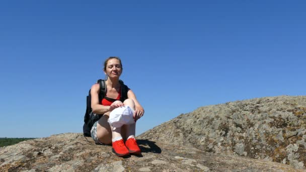 带背包的女游客坐在岩石上 休息时间 — 图库视频影像