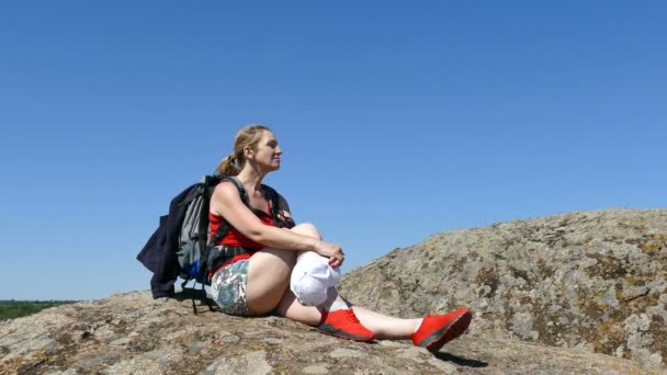 带背包的女游客坐在岩石上 户外休息时间 — 图库视频影像