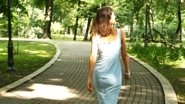 Mujer Modelo Caminar Ciudad Parque Vueltas Sonríe Cámara Lenta — Vídeo de stock