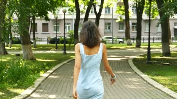 Kvinna Modell Promenad Stadsparken Vänder Sig Och Ler Slow Motion — Stockvideo