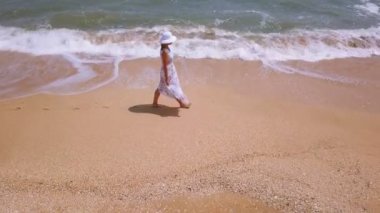 4k hava. İnce yürüyen kadın ve okyanus ya da deniz plaj. Etrafında sinek