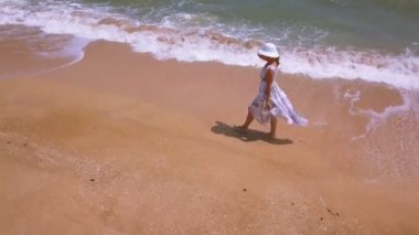 4k hava. İnce yürüyen kadın ve okyanus ya da deniz plaj üzerinde. Etrafında sinek