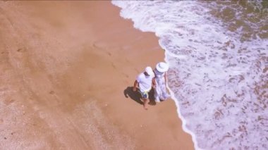 4k hava. Sevgi dolu çift okyanus ya da deniz kıyısında yürür,