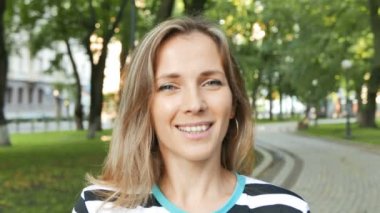           4k. Oldukça ince kadın stand ve yaz şehir parkı gülümseme. Sürekli çekim