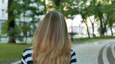           4k. Güzel bir kadın modeli açmak baş ve gülümseme. Sürekli çekimde Şehir Parkı