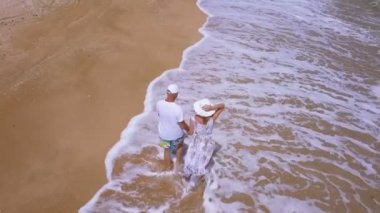    4k hava. Sevgi dolu çift okyanus kıyı şeridi üzerinde yürür. Yavaş sinek