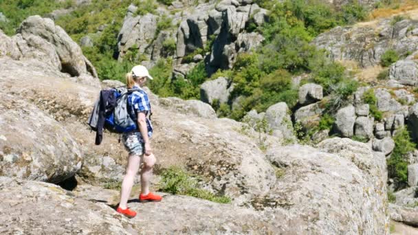 身材修长的女子游客带着背包在峡谷的岩石周围环顾四周 户外旅行队 — 图库视频影像