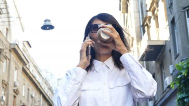  4 k. gülen iş kadın konuşmak smartphone tarafından mobil city adlı sokak. Kahve molası zamanı, sürekli atış