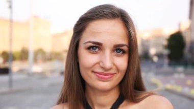  Genç kadın stand ve gülümseme şehir sokak bulanık arka planda