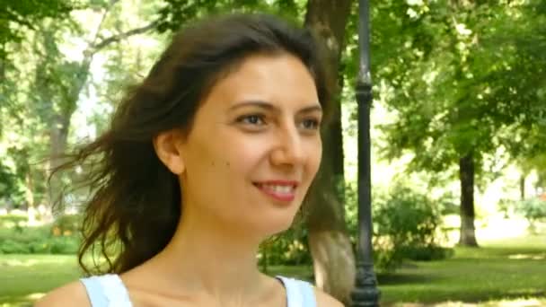 夏都市公園でかなり若い微笑んでいる女性モデルの顔 安定したショット — ストック動画