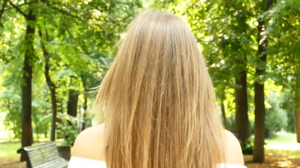 魅力的な幸せな若い長い 公園の周りに向ける笑顔の髪の女性 スローモーション 安定したショット — ストック動画