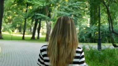 Ağır çekim. Kadın yürümek ve eller saç atar