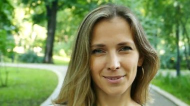 Ağır çekim. Şehir Parkı içinde güzel kadın portresi. Yüzünü kapat