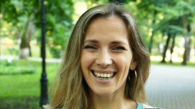 Ağır çekim. Şehir Parkı içinde güzel kadın portresi. Yüz yakın çekim, sürekli çekim