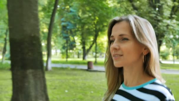 ウォーキング笑顔市夏の公園のきれいな女性 安定したショット — ストック動画
