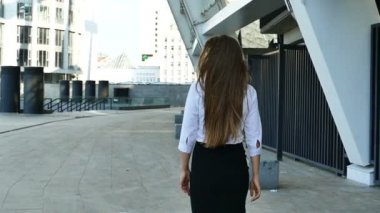 Ağır çekim. Genç uzun saç iş kadını office bölgede yürüyüş geri çevirir ve gülümseme