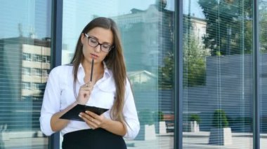 4. ciddi çekici iş kadını ofis bölgesi içinde klasör penceresi yakınındaki yazıyor. Sürekli çekim