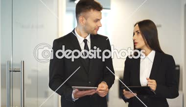 4k. Yakışıklı işadamı ve güzel işkadını tablet ile bir şey hakkında tartışmak