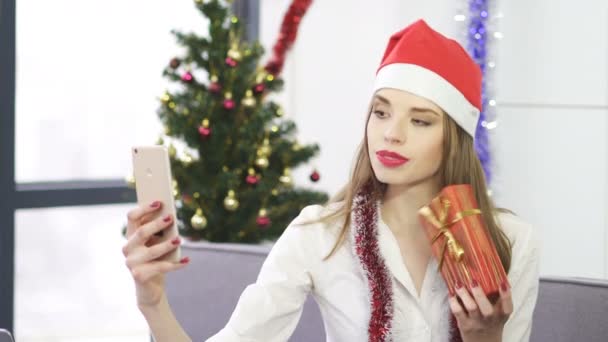 Junge Lächelnde Geschäftsfrau Mit Rotem Weihnachtsmann Hut Macht Selfie Mit — Stockvideo