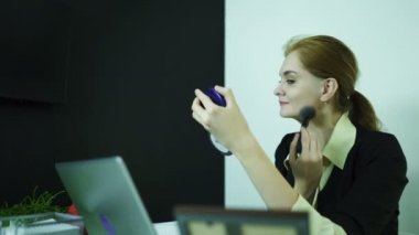 4k. Genç kız Yöneticisi ofiste makyaj düzeltir