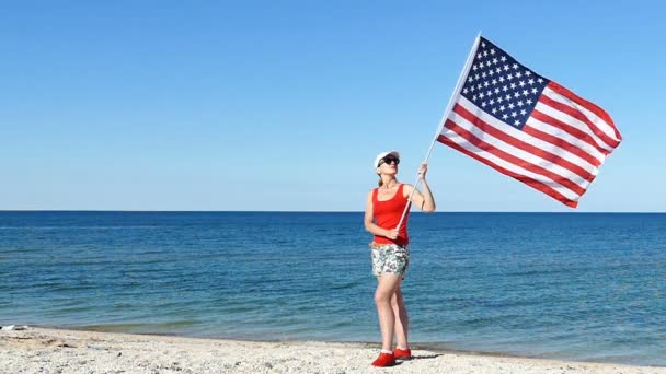 爱国漂亮的女人站与美国旗子在海附近 — 图库视频影像
