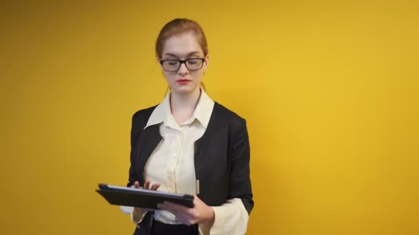 漂亮的女商人在办公室与平板电脑 稳定的镜头 黄色的墙壁 — 图库视频影像