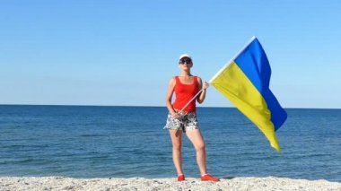 Vatansever Ukraynalı kadınla deniz sahil bayrak. Ağır çekim