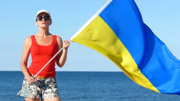 爱国严肃的妇女与乌克兰旗子在海附近 慢动作人像 — 图库视频影像