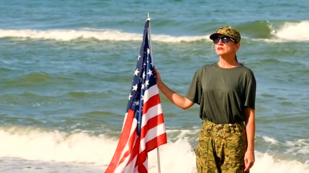 Γυναίκα Καυκάσιος Στρατιώτης Αμερικανική Σημαία Κοντά Στη Θάλασσα Αργή Κίνηση — Αρχείο Βίντεο