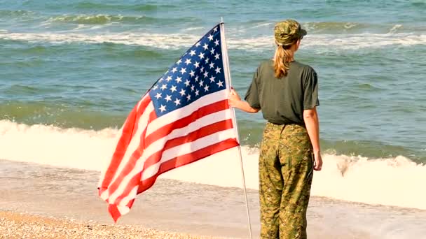 海岸近くのアメリカの国旗と兵士の女性 スローモーション — ストック動画